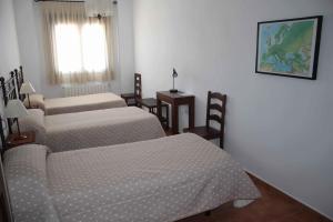 a room with three beds and a window at Casa Rural La Fuente del Coso in Cabeza la Vaca