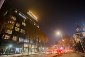 a city street at night with a building and cars at Mir Luxe Plaza in Tashkent