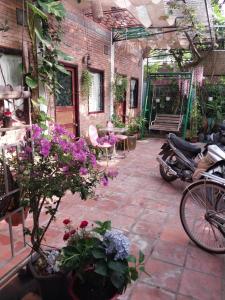 eine Terrasse mit Blumen und ein Fahrrad auf einer Terrasse in der Unterkunft Green Sunshine in Cần Thơ