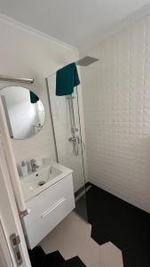 bagno bianco con lavandino e specchio di Cotroceni Studio a Bucarest