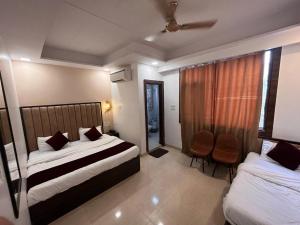a hotel room with two beds and a window at The Divine Oak in Katra