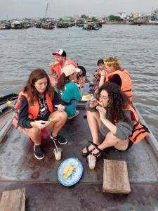 eine Gruppe von Menschen, die auf einem Boot im Wasser sitzen in der Unterkunft Green Sunshine in Cần Thơ