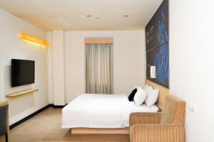 een hotelkamer met een bed en een stoel bij Zodiak Paskal by KAGUM Hotels in Bandung