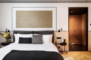 a bedroom with a large bed with a black blanket at Juno Hotel Sofia, a Member of Design Hotels in Sofia