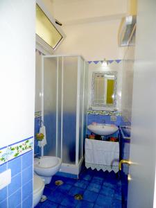 ein Badezimmer mit einem Waschbecken, einem WC und einem Spiegel in der Unterkunft Dimora Carlo III in Vietri