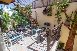 uma varanda com cadeiras e uma escadaria com plantas em La Casa Del Almendro em Playa del Carmen