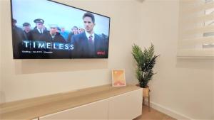 a flat screen tv on a wall in a living room at Apartamento Elena - coqueto, tranquilo y céntrico in Murcia