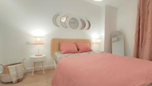 a bedroom with a pink bed with a pink blanket at Apartamento Elena - coqueto, tranquilo y céntrico in Murcia