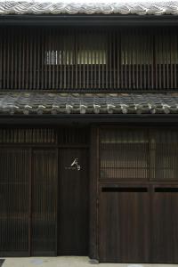 een paar houten garagedeuren op een gebouw bij 屋子 Wuz Marutamachi in Kyoto