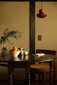 a dining room table with a bowl of fruit on it at 屋子 Wuz Marutamachi in Kyoto