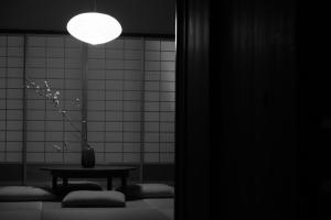 una habitación con una mesa y un jarrón con una planta en 屋子 Wuz Marutamachi en Kyoto