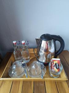 vassoio con bollitore per tè e contenitori in vetro su un tavolo di Made Oka Homestay and Warung a Munduk