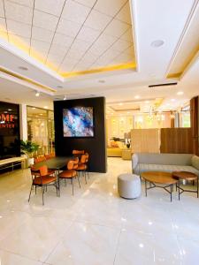 - un hall avec une télévision, des tables et des chaises dans l'établissement Hotel 365Luxhomeriverside Can Tho, à Ấp Yên Thượng