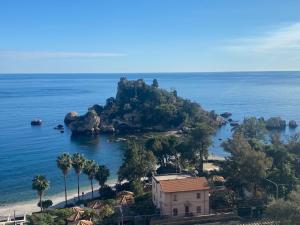 un'isola nell'oceano con una casa e palme di 202 Luxury pool Isola Bella a Taormina