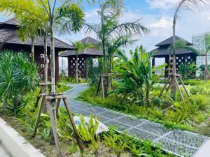 a path through a garden with trees and houses at Melaka Town Homestay Bali Residences Apartment in Melaka