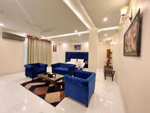 a living room with blue couches and a table at Hotel One Swat in Swat