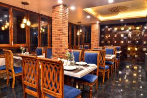 a restaurant with tables and chairs and a brick wall at Rufina Pinasa Residency in Gangtok