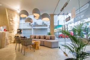 a living room with a couch and a table and chairs at The Cave By Cactus Hotel Skudai in Skudai