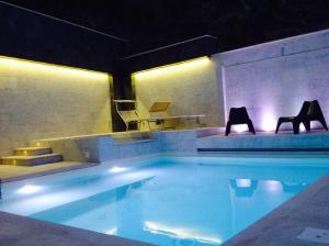 una piscina con due sedie e un tavolo di 202 Luxury pool Isola Bella a Taormina