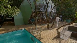 una casa con piscina junto a una terraza de madera en The Machan, en Lonavala