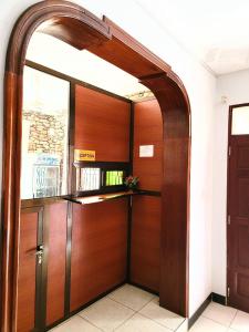 uma entrada para um edifício com uma porta de madeira em Jm Lodge - Kunduchi em Dar es Salaam