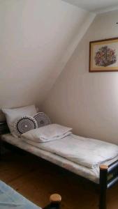 un letto con lenzuola e cuscini bianchi in una stanza di Dom Olena a Güldenboden