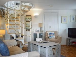 徹斯頓費斯的住宿－Swallows Cottage，客厅设有木桌和螺旋楼梯。