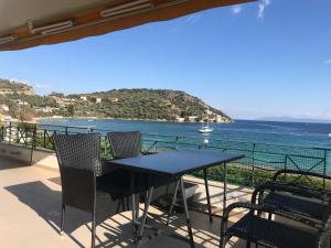 - stół i krzesła na balkonie z widokiem na ocean w obiekcie Golden Coast Panagias Apartment w mieście Wolos