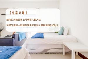 a bedroom with two beds and a table at Travel Road WuWu in Taitung City