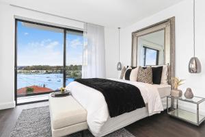 a bedroom with a bed and a large window at Luxury Waterside Home in Sydney