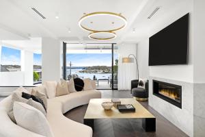 a living room with a couch and a fireplace at Luxury Waterside Home in Sydney