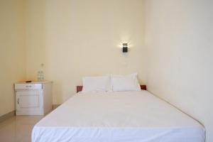 1 cama blanca con 2 almohadas en una habitación en RedDoorz near Candi Cetho Karanganyar en Karanganyar