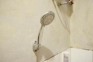 Un cabezal de ducha está pegado a una pared en RedDoorz near Candi Cetho Karanganyar en Karanganyar
