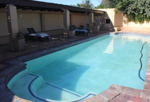 a large swimming pool with blue water in a yard at Moda Rossi in Langebaan