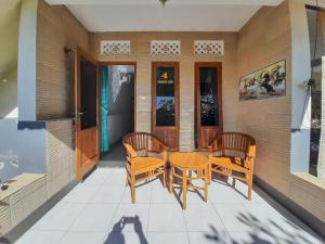 a patio with a table and chairs on a porch at Pondok Asri Homestay Munduk in Munduk