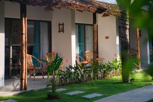 a patio of a house with chairs and a table at Sala Tuy Hoa Beach Hotel in Tuy Hoa