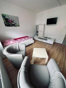 a living room with a couch and a tv at FeWo`s Katharina in Bremerhaven