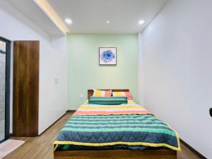 a bedroom with a bed with a colorful blanket at Thái Vân Home in Ho Chi Minh City