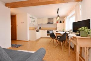 cocina y sala de estar con mesa y sillas en Familienbauernhof Köss Schertler, en Egg