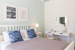 Habitación blanca con cama y escritorio en Effie's Cozy House, en Rethymno