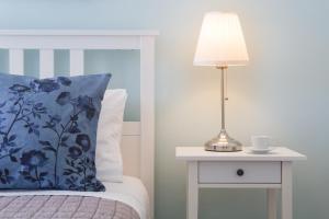 Una cama con una almohada azul y una lámpara en una mesita de noche en Effie's Cozy House, en Rethymno