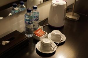 a counter with two cups and two bottles of water at Horison Ultima Bandara Balikpapan in Sepinggang-Kecil