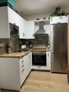 Abrucena的住宿－Casa Rural El cerrillo，厨房配有白色橱柜和不锈钢冰箱
