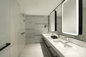 een badkamer met 2 wastafels en een douche bij Crowne Plaza Dalian Xinghai, an IHG Hotel in Dalian