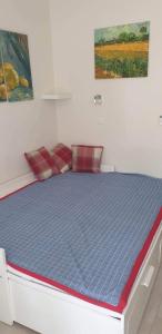 uma cama num quarto com um colchão azul em Csopak Apartman em Csopak