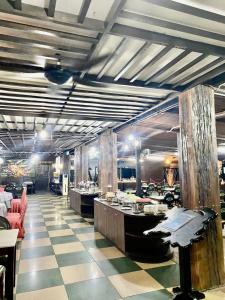 un restaurante con suelo a cuadros y un comedor en De Baron Resort en Kuah
