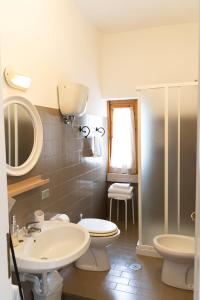 a bathroom with a sink and a toilet and a mirror at Hotel Mom Assisi in Assisi