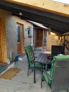 eine Terrasse mit einem Holztisch und Stühlen auf einer Terrasse in der Unterkunft 2 bedroom 1 bath apartment in Kruså