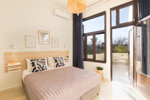 1 dormitorio con cama y ventana grande en Effie's Cozy House, en Rethymno