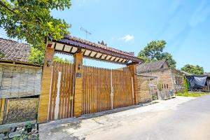 an entrance to a wooden gate to a house at OYO 92367 Garuda Homestay Syariah in Banyuwangi